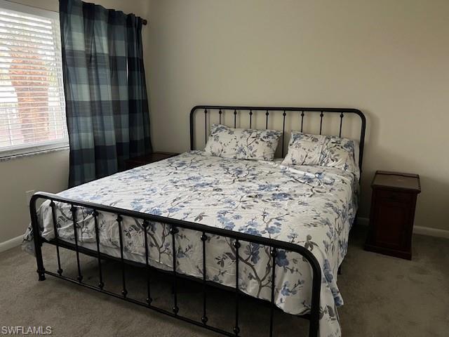 3250 10th Street North, Unit A6 Naples, FL 34103 - Photo 8 of 12 a bed sitting in a bedroom next to a window