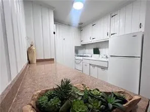 a kitchen with stainless steel appliances granite countertop a refrigerator sink and white cabinets