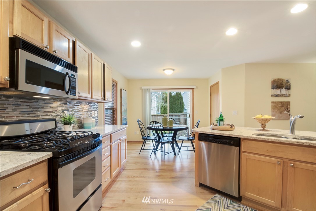 34829 Southeast Ridge Street Snoqualmie, WA 98065 - Photo 5 of 19 a kitchen with stainless steel appliances granite countertop a stove a sink a microwave a dining table and chairs