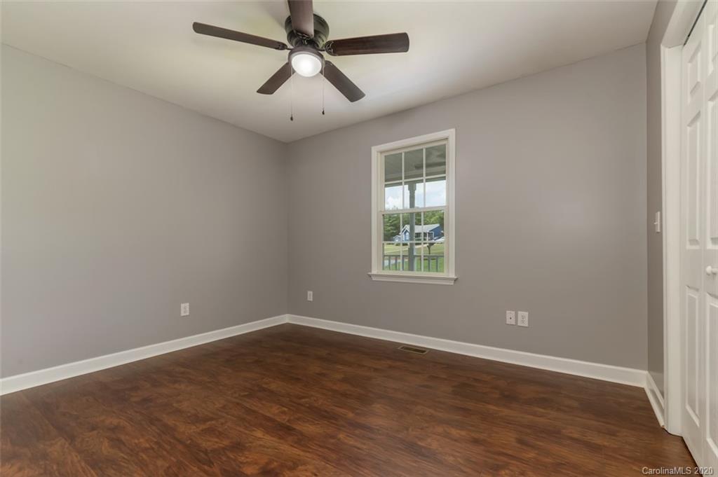 136 Carolina Paradise Road Rutherfordton, NC 28139 - Photo 8 of 30 an empty room with wooden floor ceiling fan and window