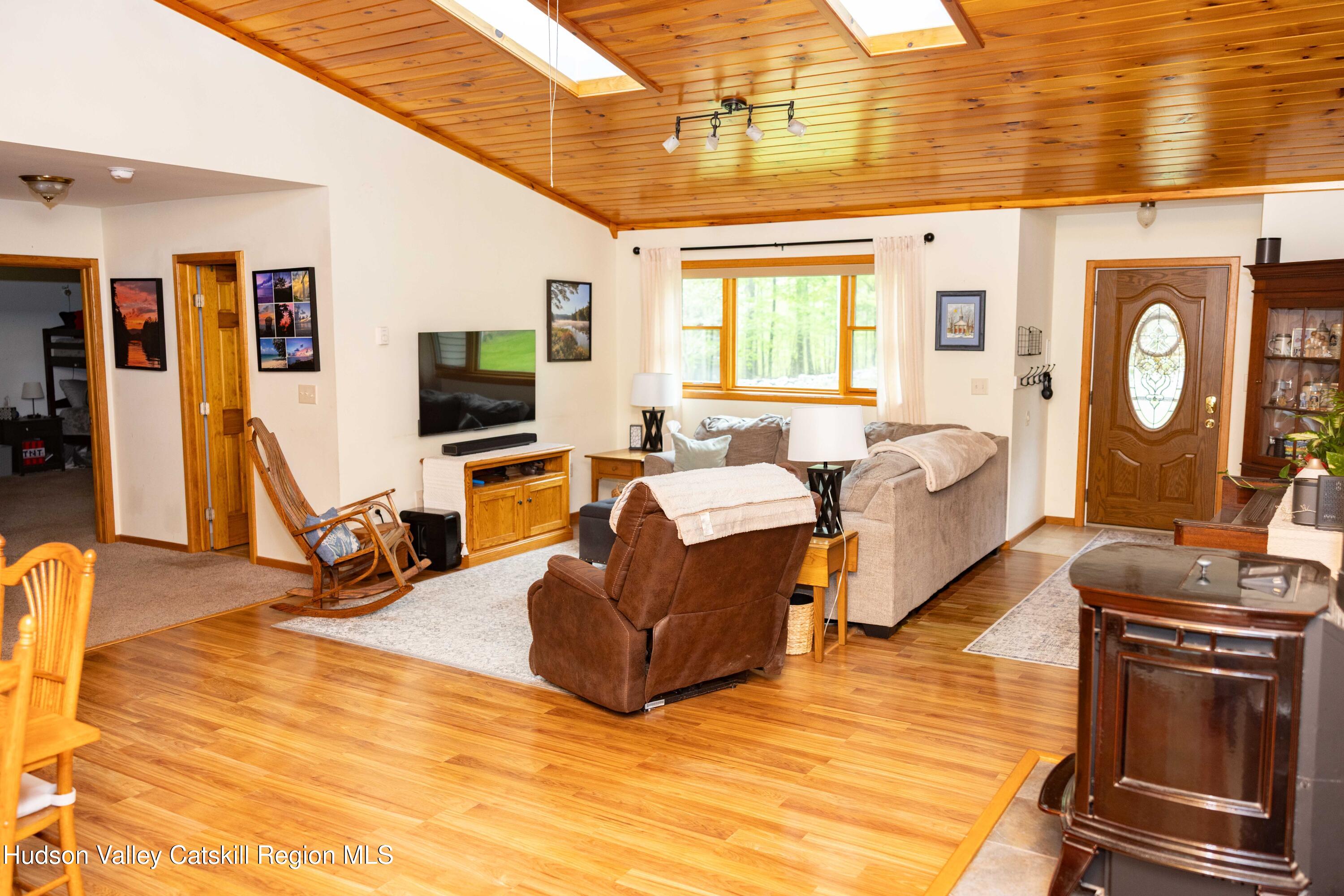 736 Plattekill Road Freehold, NY 12431 - Photo 15 of 47 a living room with furniture a flat screen tv and a large window