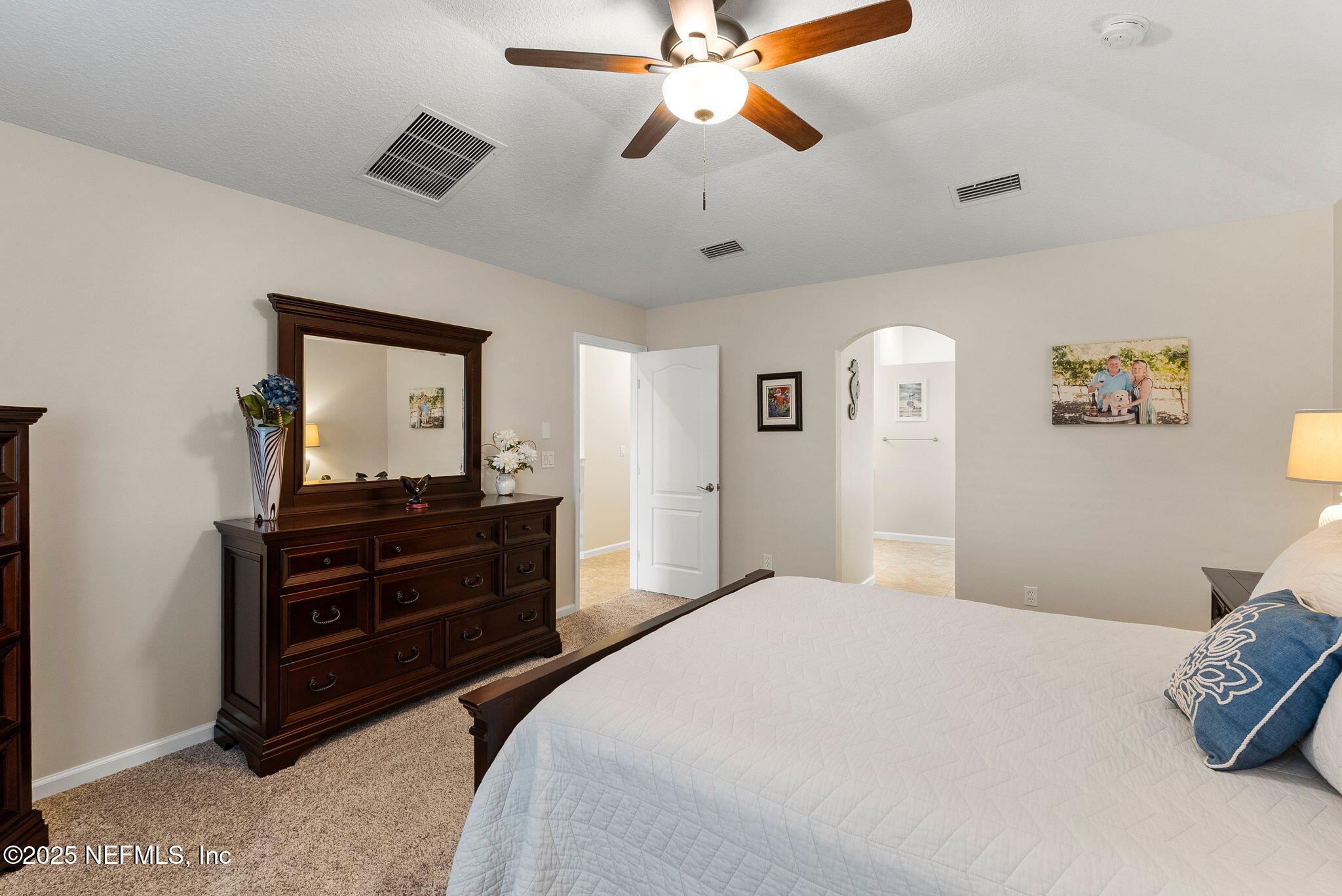 1428 Riva Del Garda Way St. Augustine, FL 32092 - Photo 23 of 44 a bedroom with a bed and a mirror on dresser