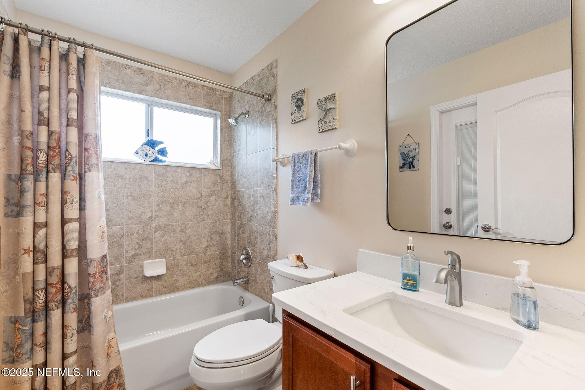 1428 Riva Del Garda Way St. Augustine, FL 32092 - Photo 29 of 44 a bathroom with a granite countertop sink toilet a large mirror a bathtub and shower