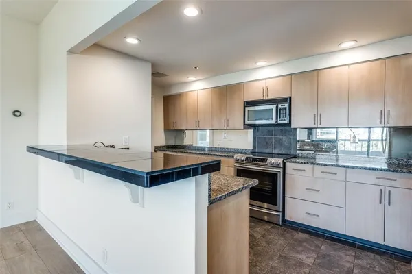 a kitchen with stainless steel appliances granite countertop a sink and stove top oven