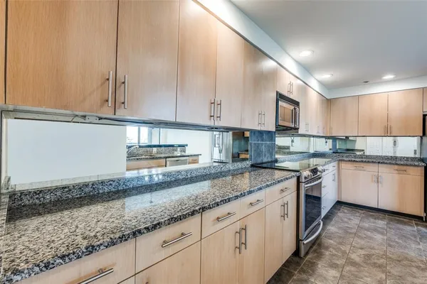 a kitchen with granite countertop a sink a stove and cabinets