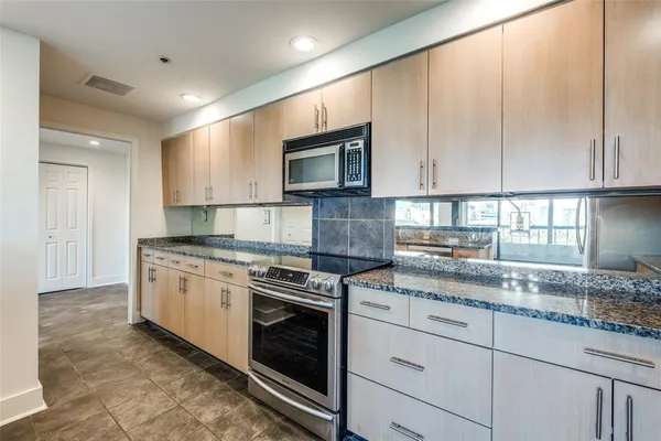 a kitchen with granite countertop cabinets stainless steel appliances and a sink