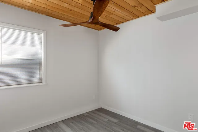 a view of a small space with wooden floor and a window