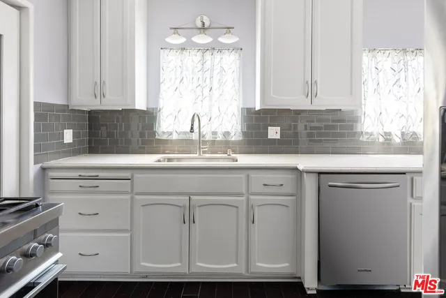 a kitchen with granite countertop white cabinets and white appliances