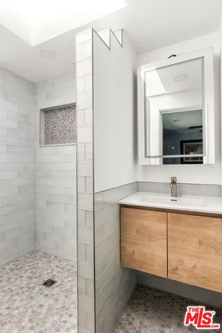 a bathroom with a sink a mirror and shower