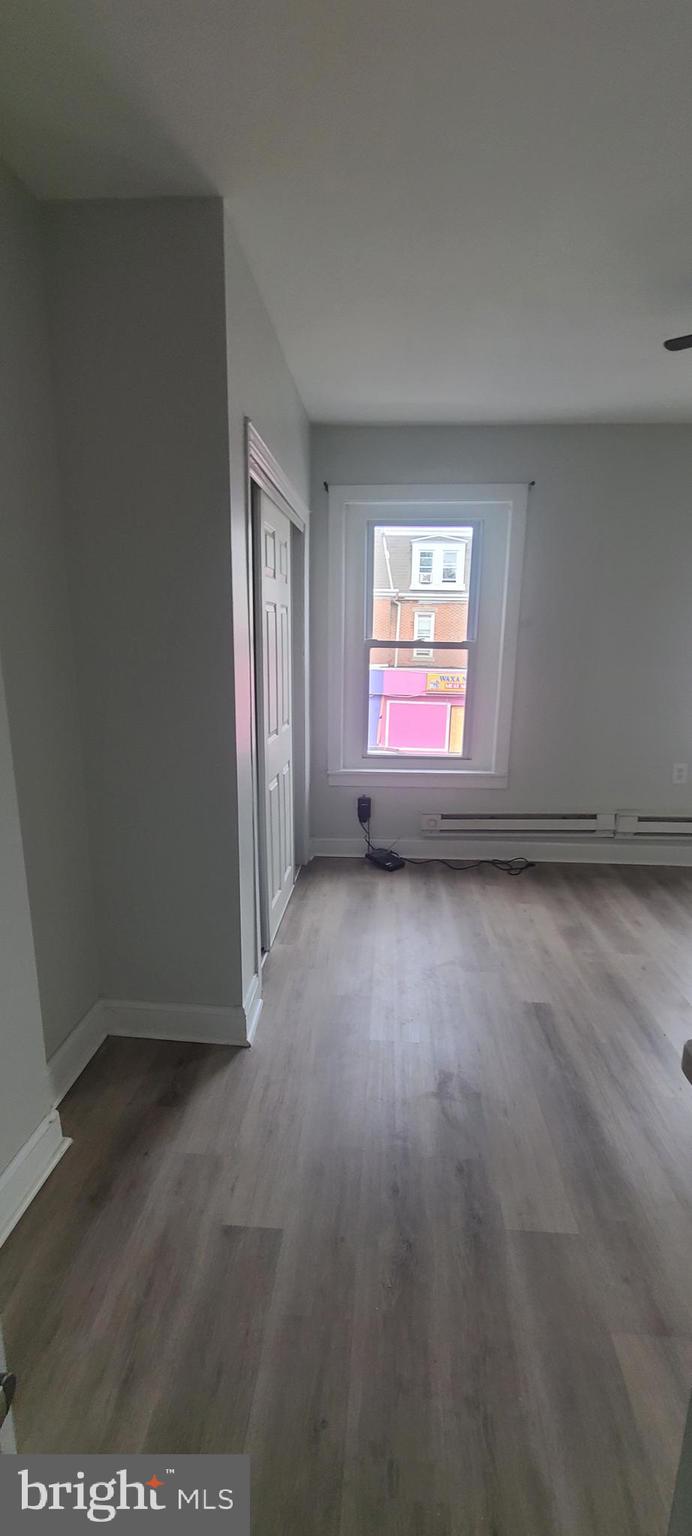 2026 Edgmont Avenue Chester, PA 19013 - Photo 4 of 11 an empty room with wooden floor and windows