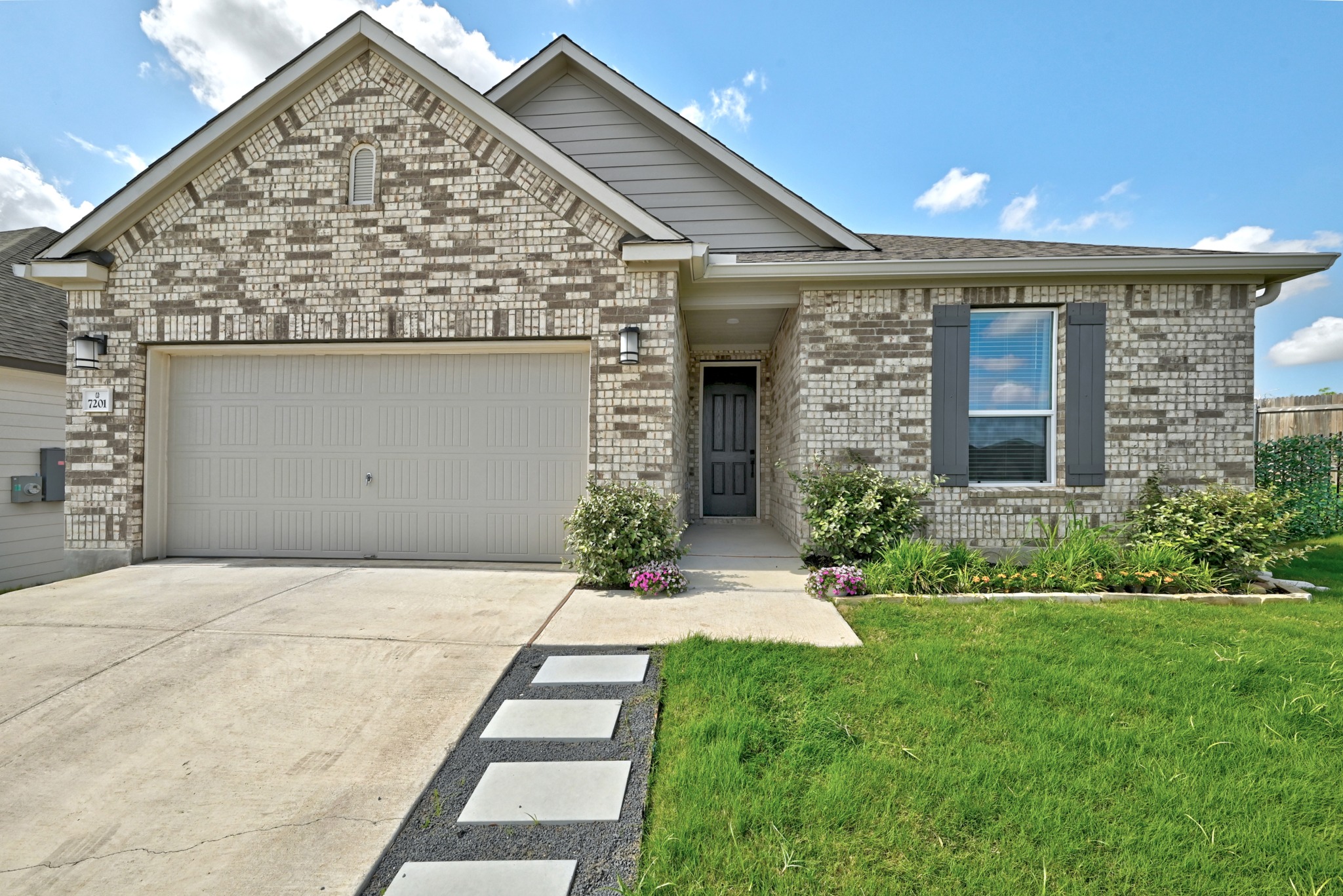 7201 Calliope Crossing Austin, TX 78744 - Photo 2 of 22 a front view of a house with a yard and garage