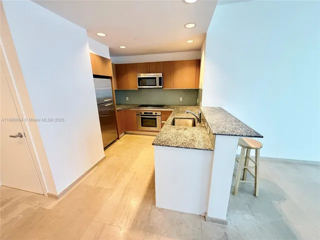 a kitchen with stainless steel appliances granite countertop a sink and a stove
