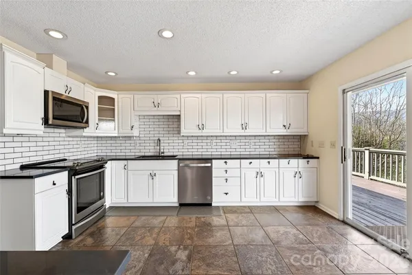 a kitchen with granite countertop a stove sink and cabinets