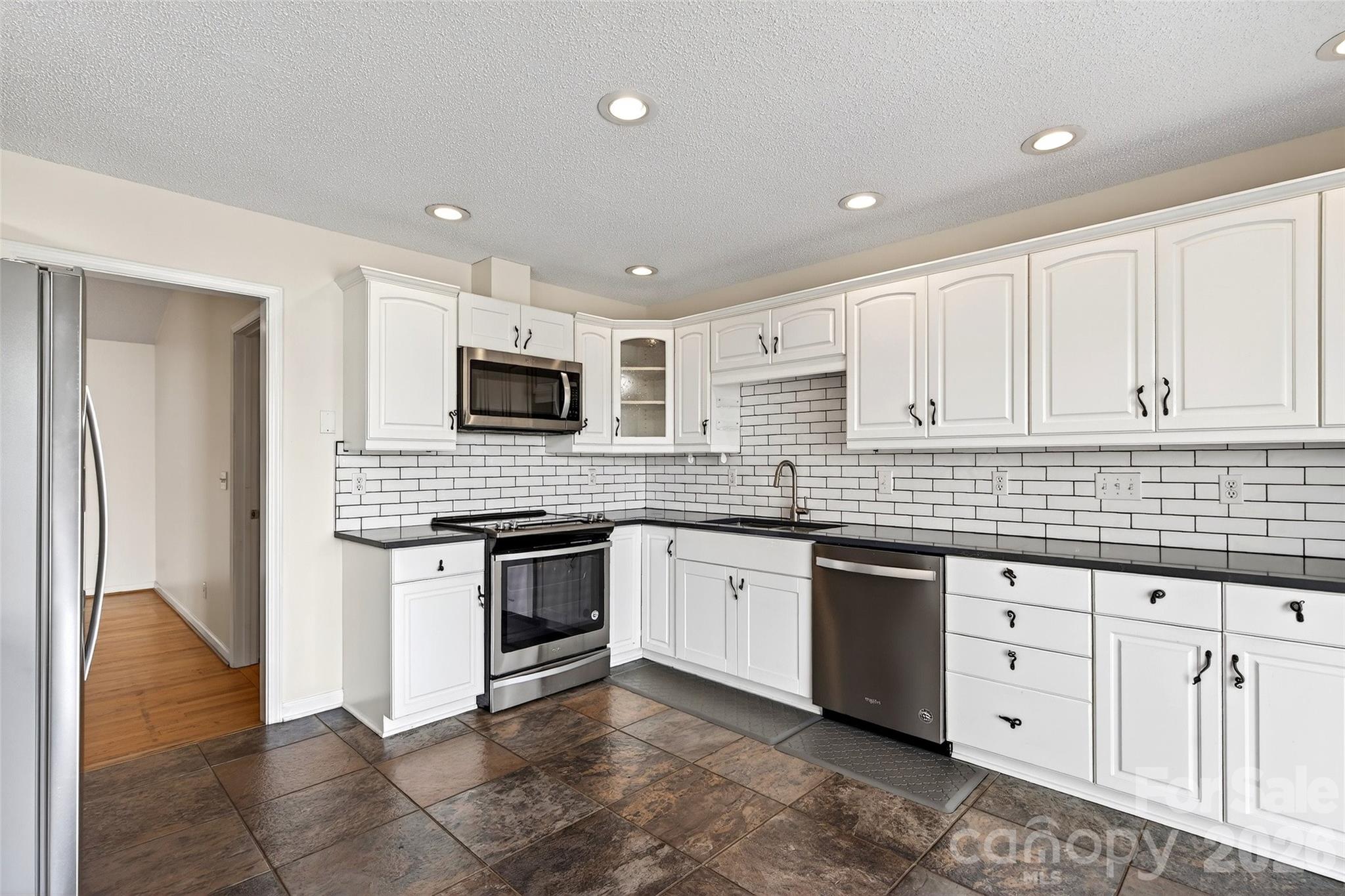 3 Tree Top Place Black Mountain, NC 28711 - Photo 16 of 43 a kitchen with granite countertop white cabinets and stainless steel appliances