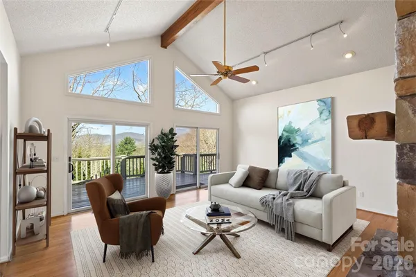 a living room with furniture a ceiling fan and a large window