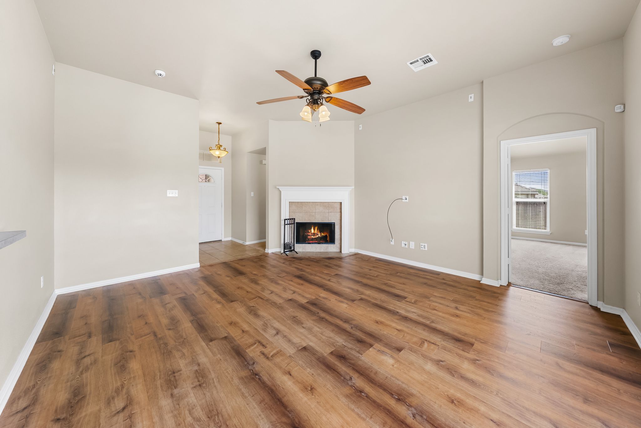 7719 Fieldstone Drive Temple, TX 76502 - Photo 11 of 37 Unfurnished living room with a tile fireplace, ceiling fan, and dark wood finished floors