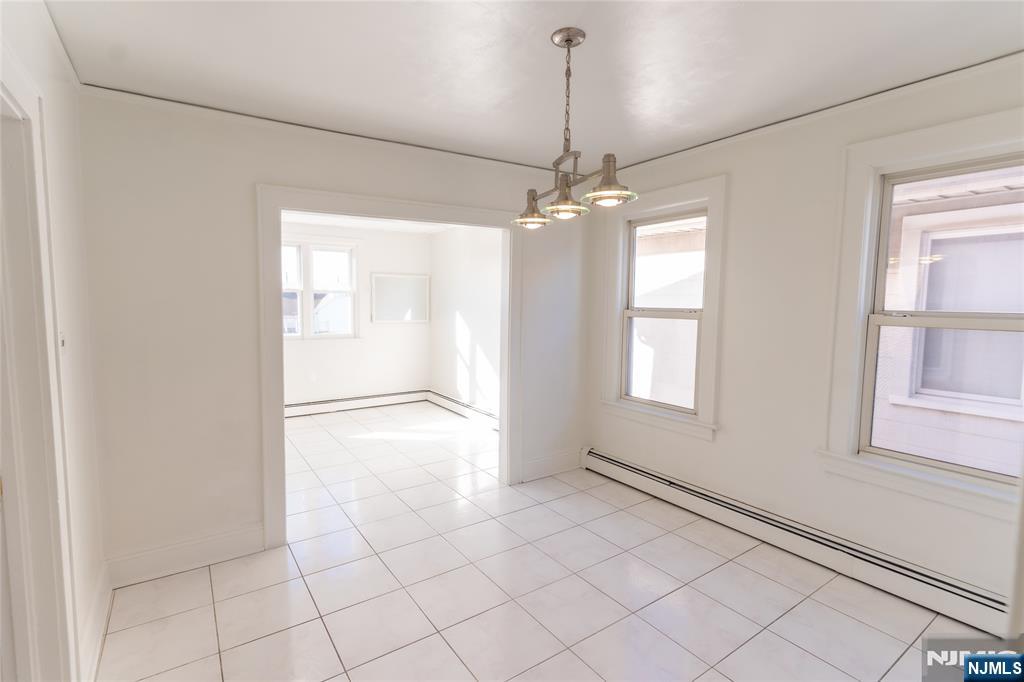 125 Clark Place, Unit 123 Elizabeth, NJ 07206 - Photo 6 of 16 a view of an empty room with window and chandelier fan