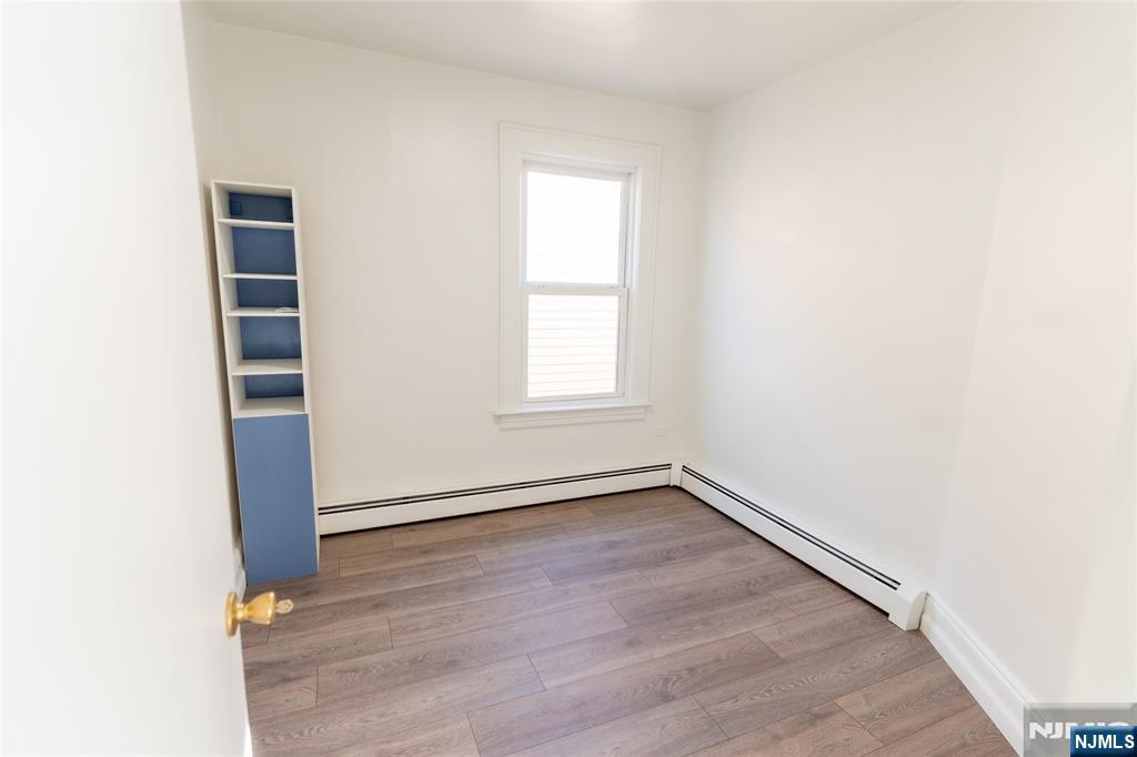 125 Clark Place, Unit 123 Elizabeth, NJ 07206 - Photo 7 of 16 an empty room with wooden floor and window