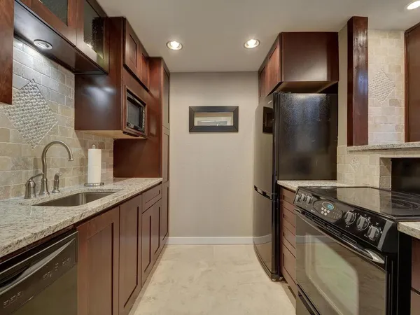 a kitchen with stainless steel appliances granite countertop a sink stove and refrigerator