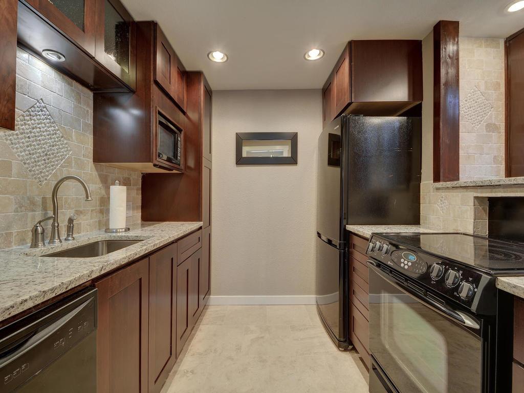 2529 Rio Grande Street, Unit 58 Austin, TX 78705 - Photo 11 of 23 a kitchen with stainless steel appliances granite countertop a sink stove and refrigerator