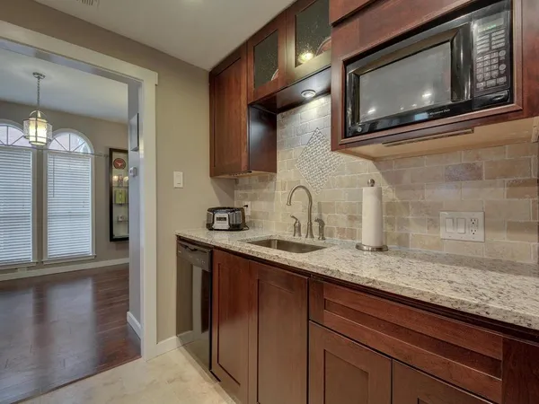 a kitchen with stainless steel appliances granite countertop a sink a stove and microwave
