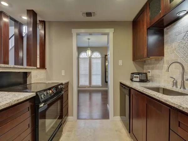 a kitchen with stainless steel appliances granite countertop a sink stove and cabinets