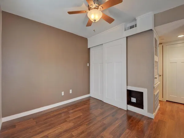 a view of an empty room with window and wooden floor