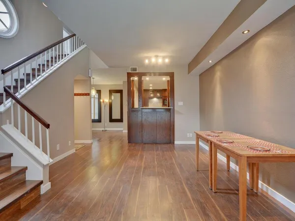 a view of a hallway with wooden floor and staircase