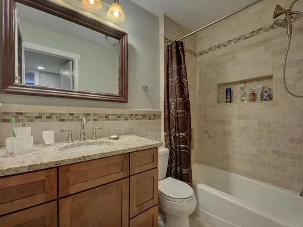 a bathroom with a granite countertop sink toilet and shower