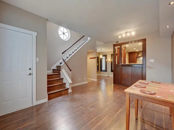 a view of a hallway with wooden floor and stairs