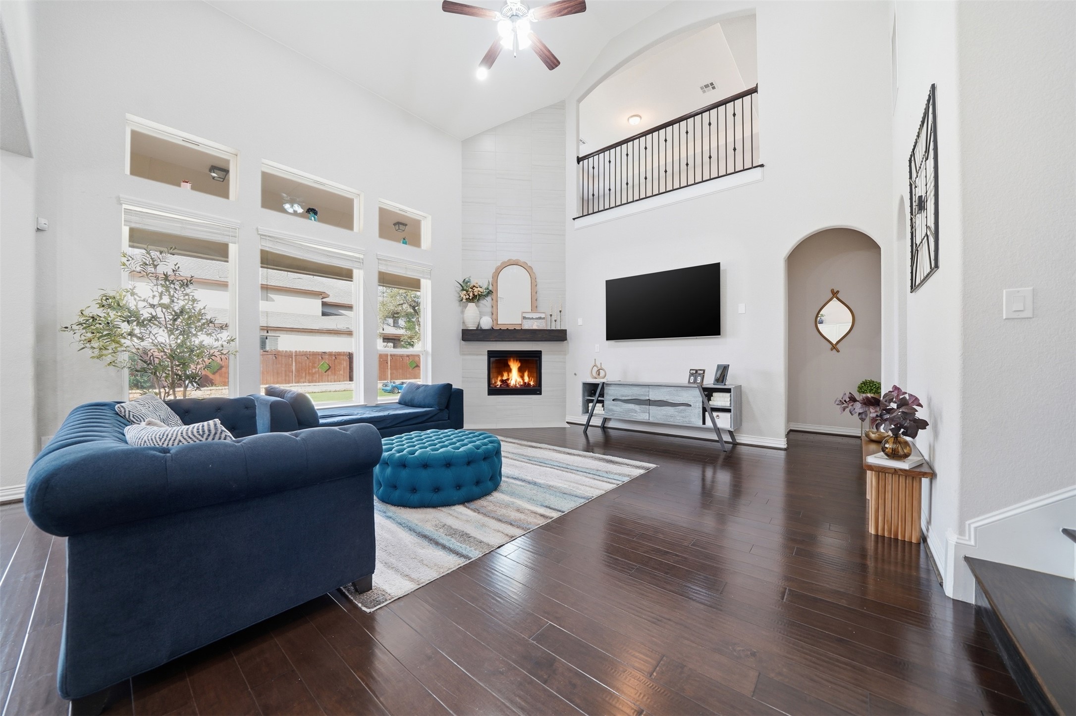 4301 Logan Ridge Drive Cedar Park, TX 78613 - Photo 11 of 38 Living area featuring a large fireplace, hardwood / wood-style flooring, arched walkways, a ceiling fan, and lofted ceiling
