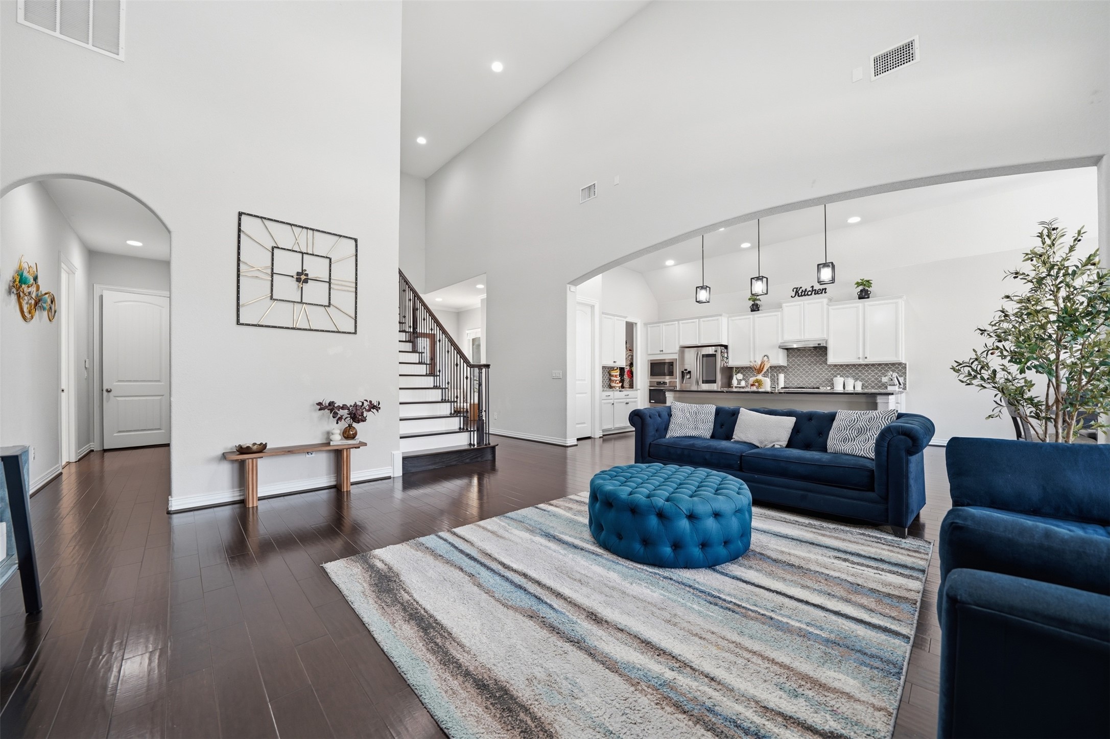 4301 Logan Ridge Drive Cedar Park, TX 78613 - Photo 12 of 38 Living room with arched walkways, dark wood finished floors, recessed lighting, and a high ceiling