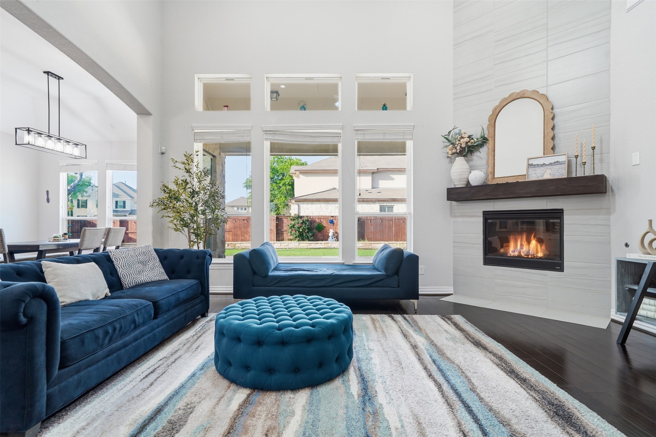 4301 Logan Ridge Drive Cedar Park, TX 78613 - Photo 13 of 38 Living room featuring a high ceiling, a tile fireplace, wood finished floors, and arched walkways