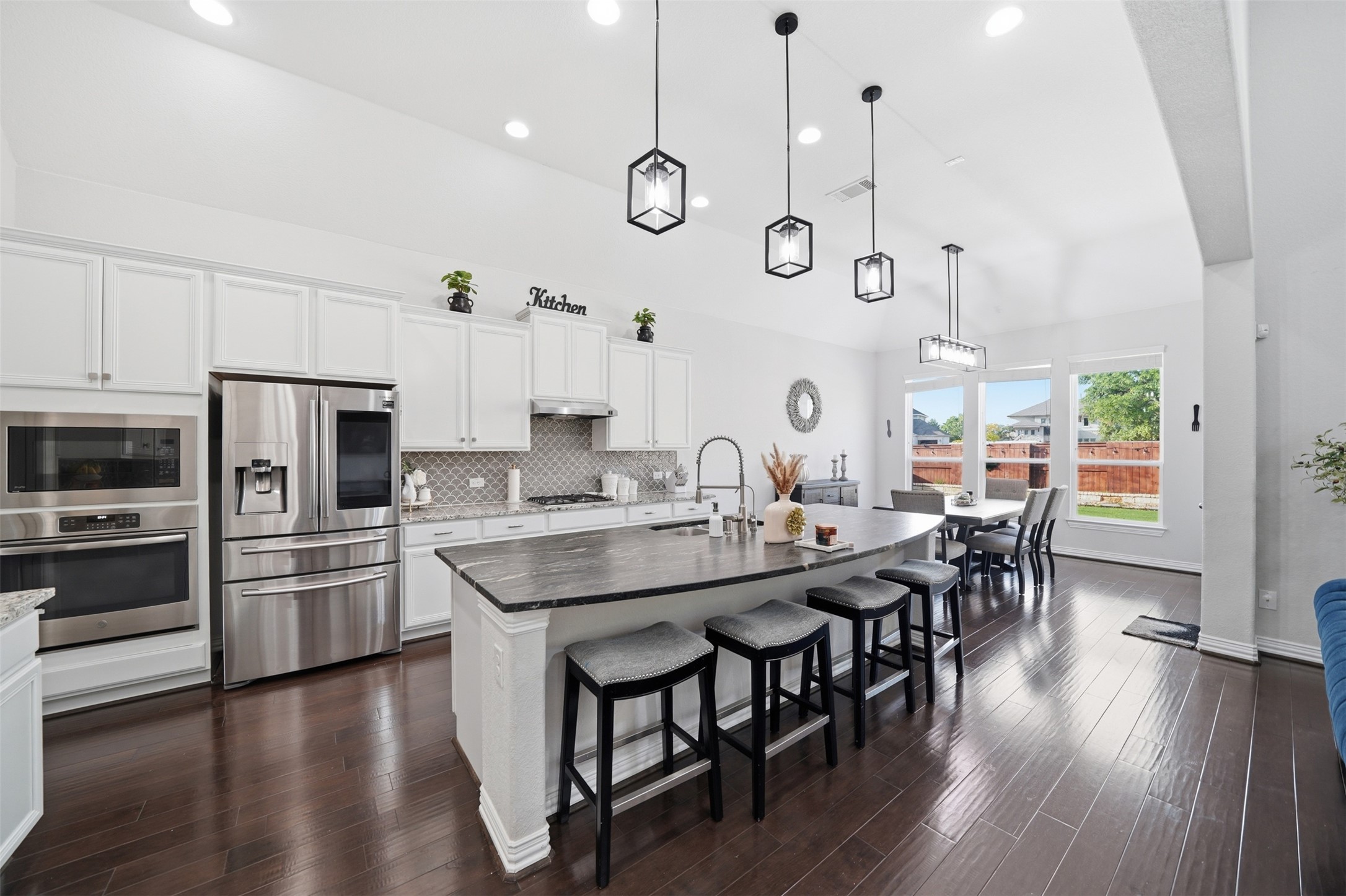 4301 Logan Ridge Drive Cedar Park, TX 78613 - Photo 14 of 38 Kitchen with white cabinetry, stainless steel appliances, a center island with sink, a kitchen breakfast bar, and hanging light fixtures