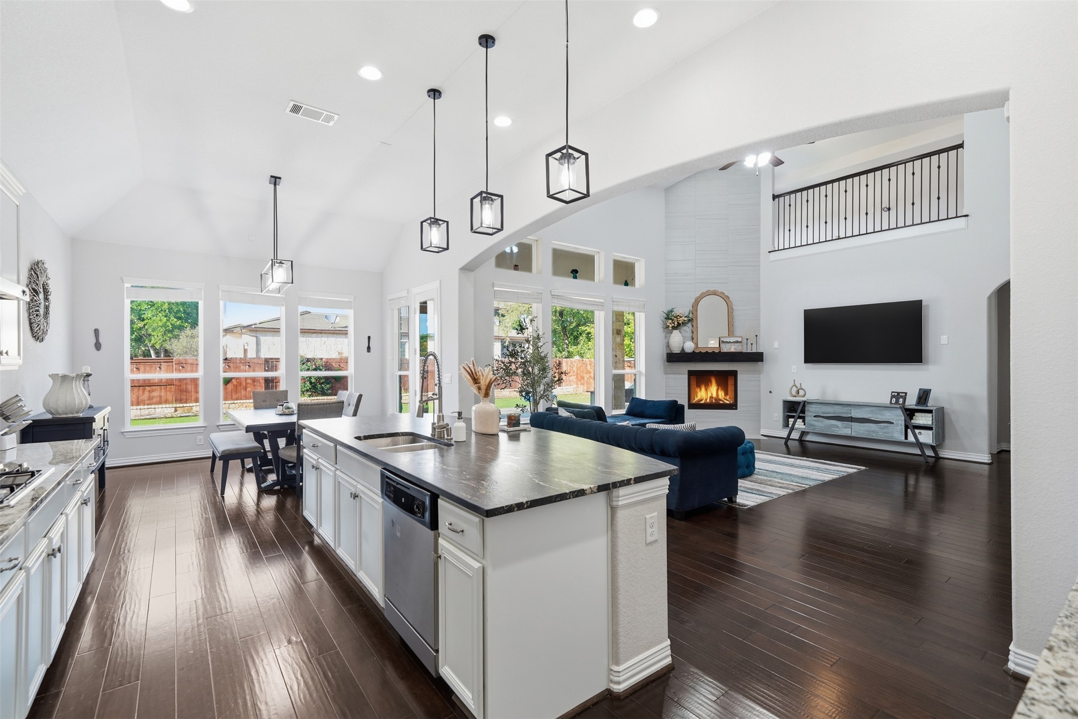 4301 Logan Ridge Drive Cedar Park, TX 78613 - Photo 37 of 38 Kitchen with white cabinets, lofted ceiling, dark wood-style flooring, open floor plan, and hanging light fixtures