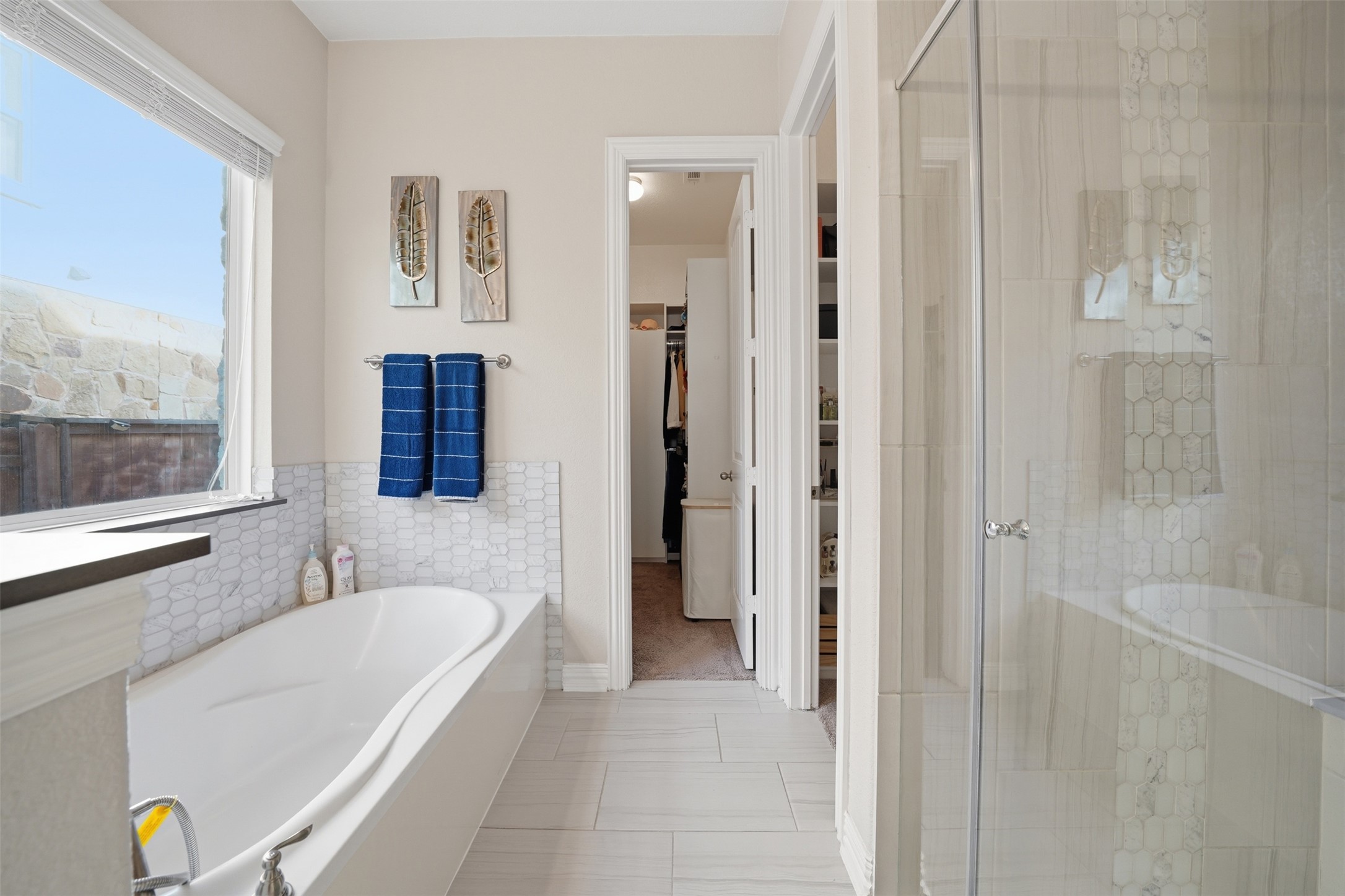 4301 Logan Ridge Drive Cedar Park, TX 78613 - Photo 18 of 38 Full bathroom featuring a bath, a stall shower, a spacious closet, and light tile patterned floors