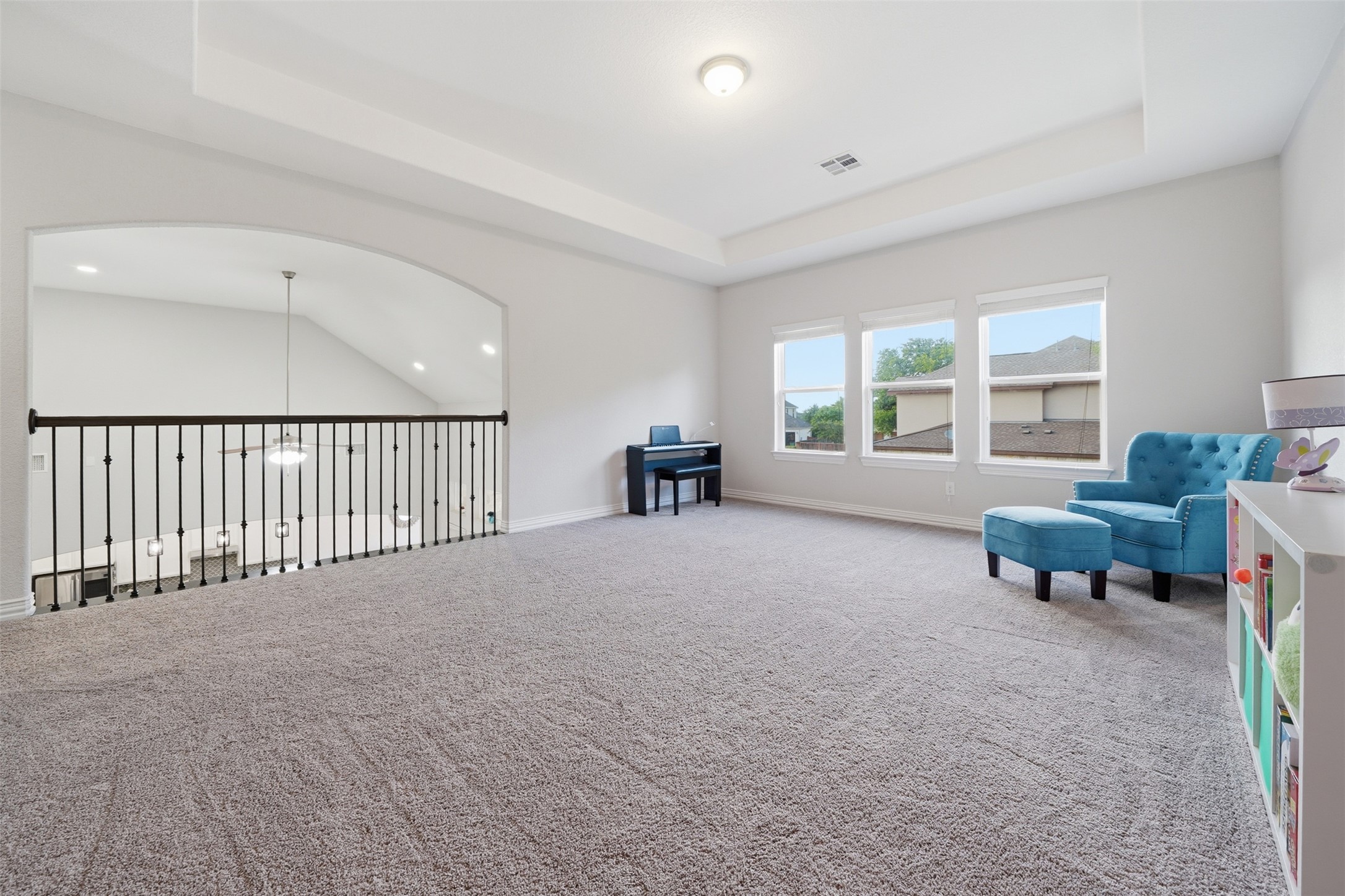 4301 Logan Ridge Drive Cedar Park, TX 78613 - Photo 27 of 38 Living area featuring carpet flooring, a tray ceiling, and arched walkways