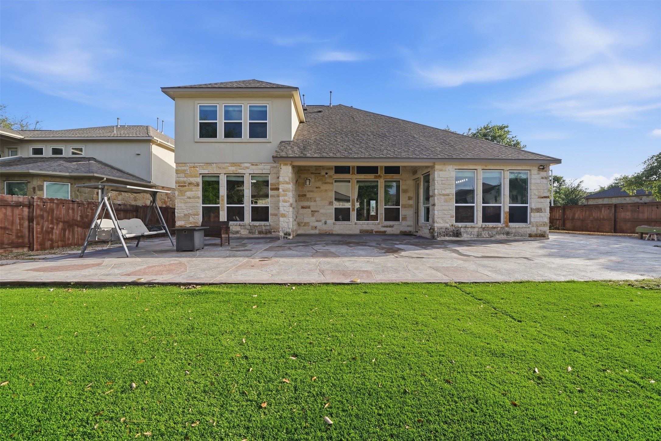 4301 Logan Ridge Drive Cedar Park, TX 78613 - Photo 35 of 38 Rear view of property with stone siding, a fenced backyard, and a patio area