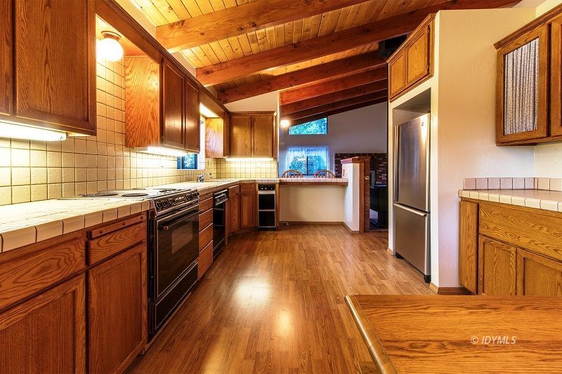 25020 Rim Rock Road Idyllwild, CA 92549 - Photo 17 of 34 a kitchen with stainless steel appliances granite countertop wooden floors and sink