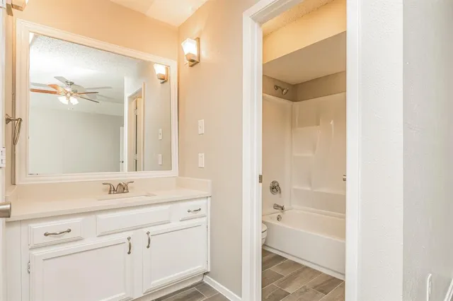a bathroom with a shower sink vanity and mirror