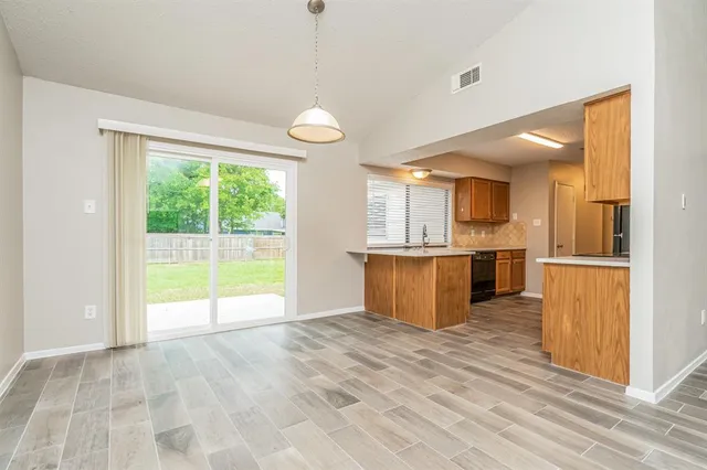 a view of kitchen with kitchen island wooden floor center island and stainless steel appliances