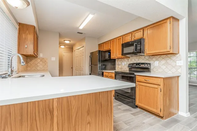 a kitchen with stainless steel appliances kitchen island granite countertop a stove a sink and a microwave