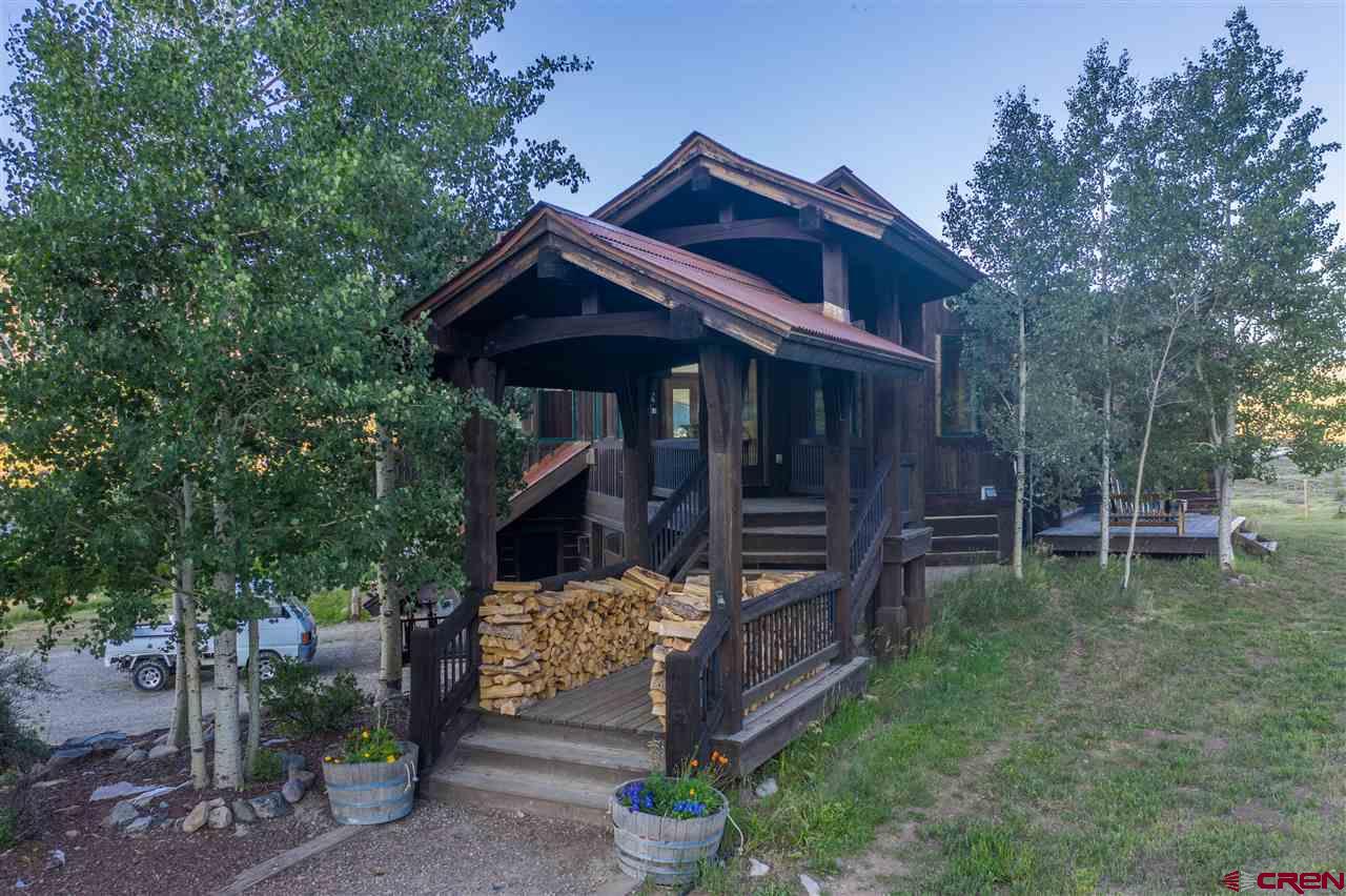 379 Smith Road Crested Butte, CO 81224 - Photo 7 of 35 a view of a wooden house with a small yard and large trees