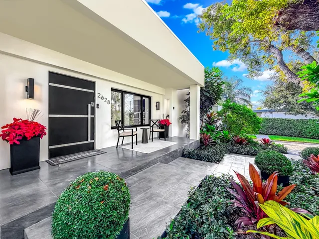 a view of a dining room with furniture large windows and a chandelier
