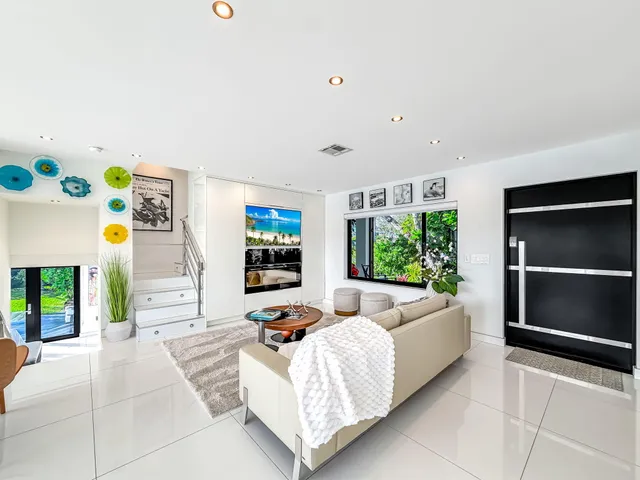a dining room with stainless steel appliances kitchen island granite countertop a sink and wooden floor