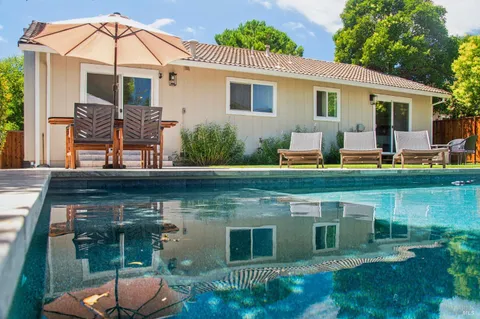 a view of a house with backyard sitting area and garden