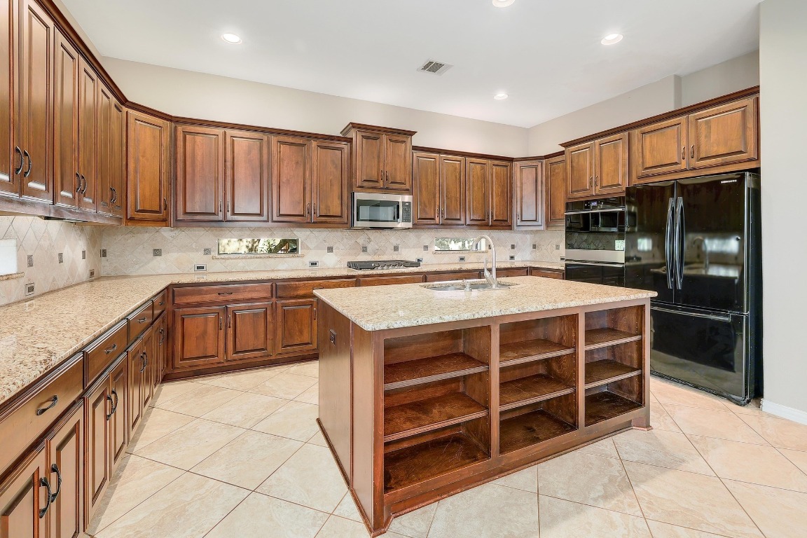 1900 Alamo Bound Leander, TX 78641 - Photo 13 of 38 a kitchen with stainless steel appliances a stove sink and cabinets