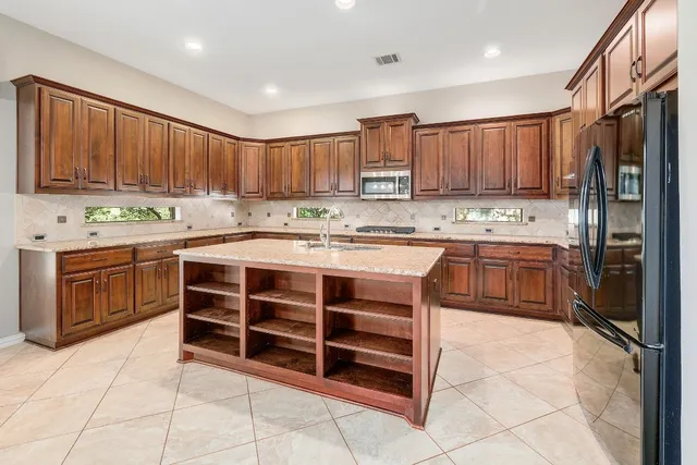 a kitchen with a stove sink and cabinets