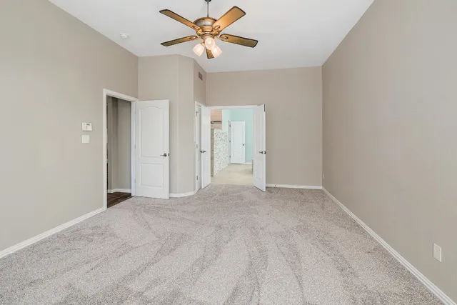 an empty room with closet and a chandelier fan