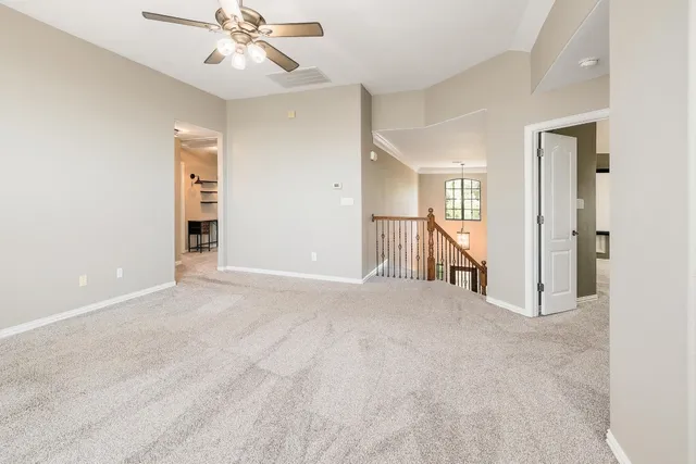 an empty room with closet and a ceiling fan